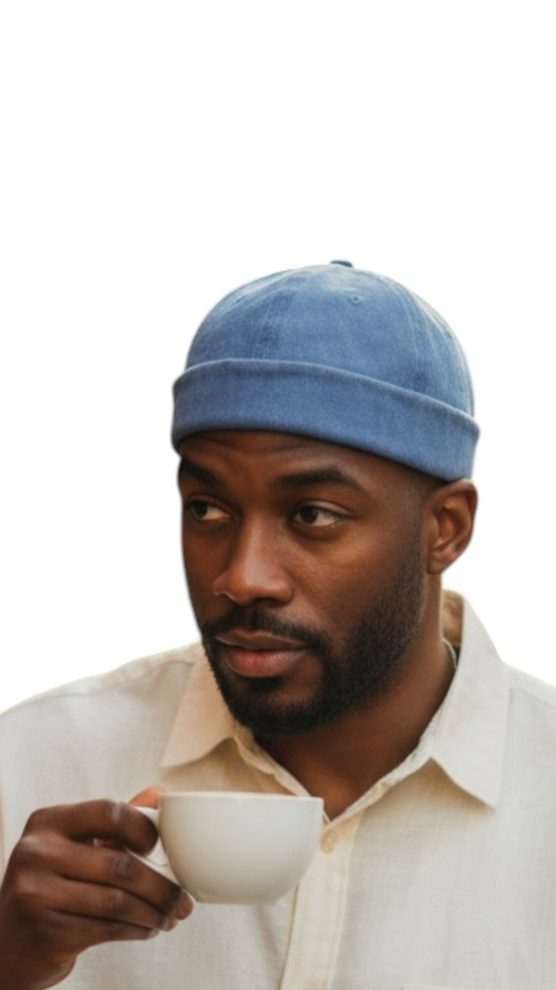 Peacefulcornerapparel distressed blue cotton docker hat on a man holding a white coffee cup.